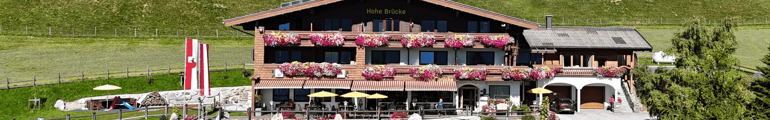 Alpenhaus mit Balkon, Blumen und Terrasse in der Natur