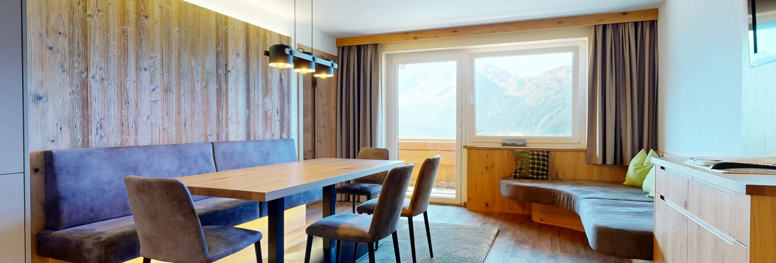 Innenansicht eines modernen Raums mit Essbereich und Blick auf die Berge