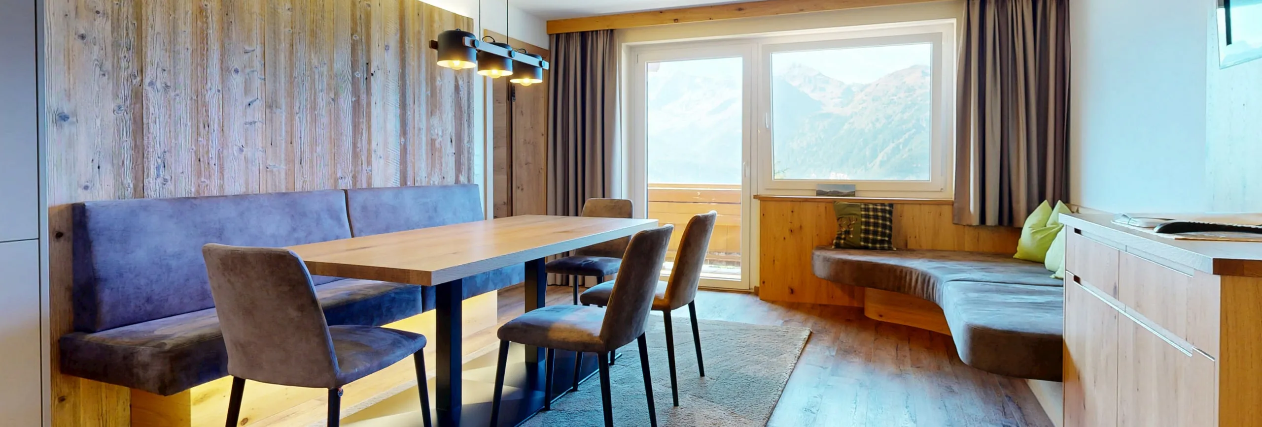 Moderne Wohnung im Bergstil mit Holzmöbeln und Fensterblick auf die Berge